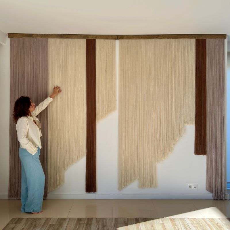 Handmade fiber art wall hanging displayed in a modern neutral interior
